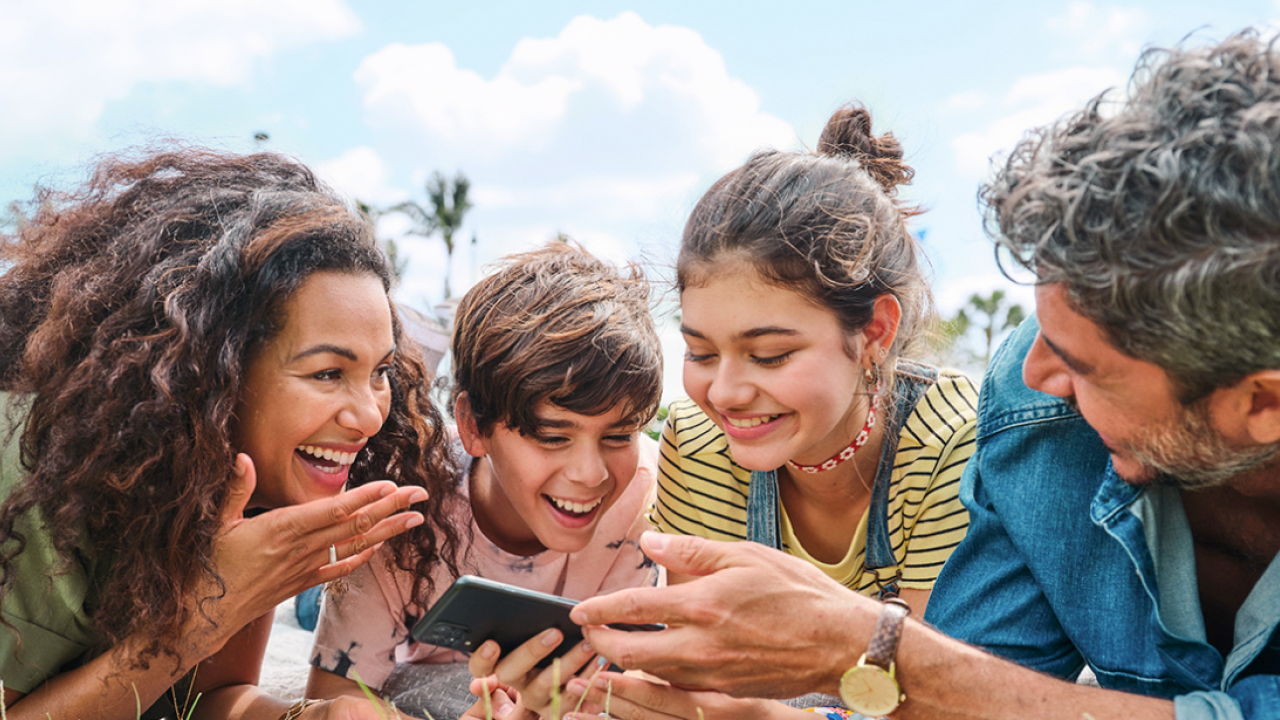 family looking at phone laughing