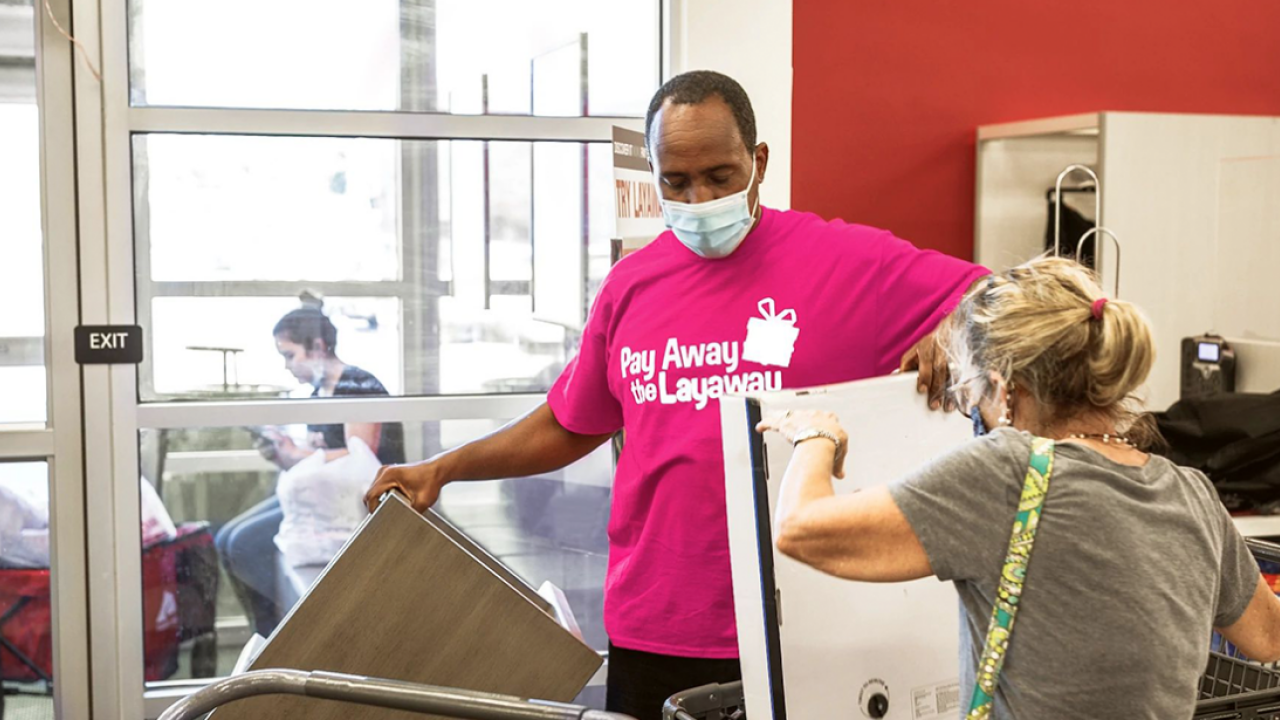 Man in Pay Away the Layaway shirt helping woman with boxes