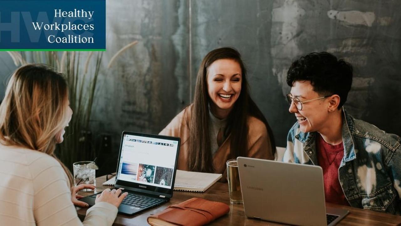 Three people sat at a table on laptops