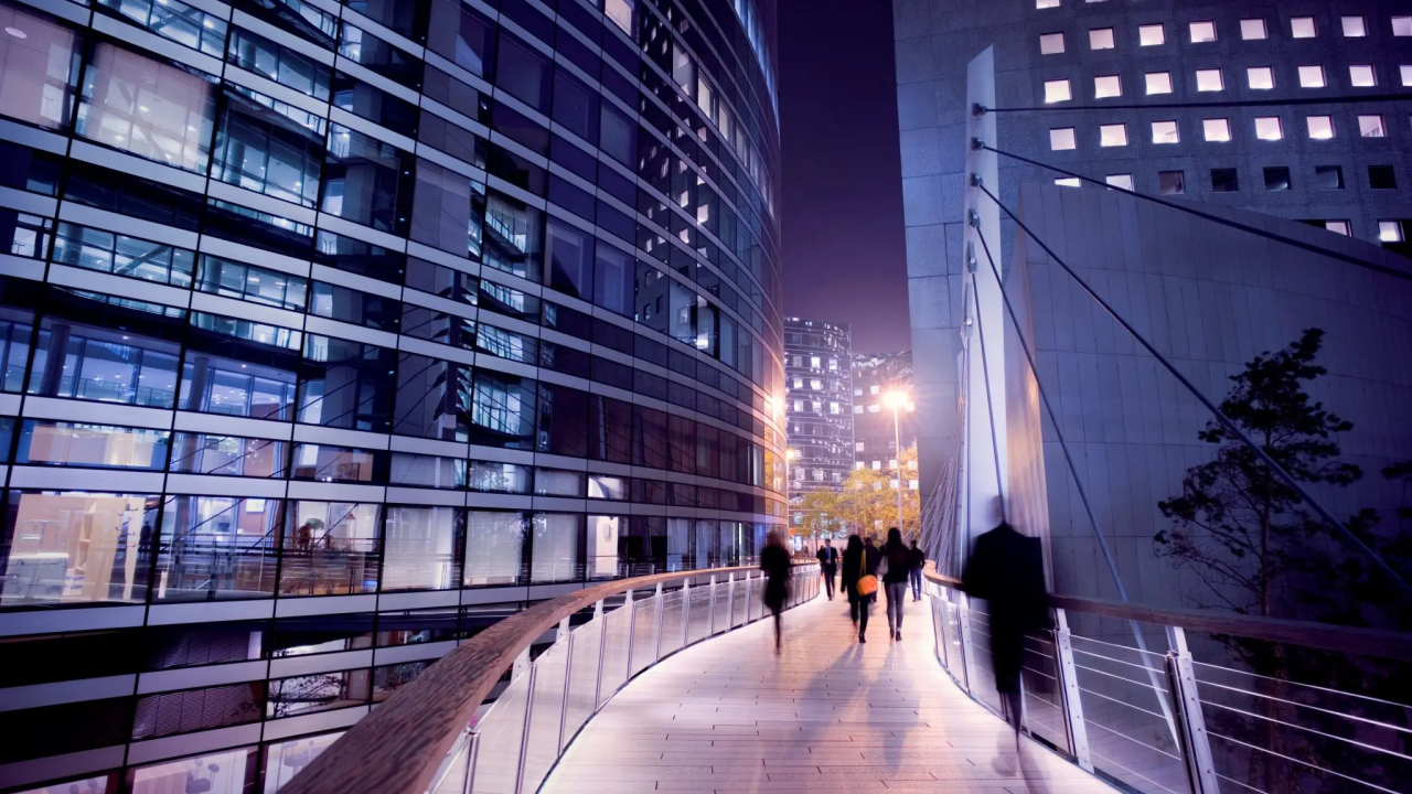 People on a walkway between two tall buildings