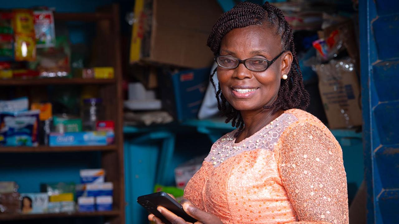 Person smiling while using smartphone at a business