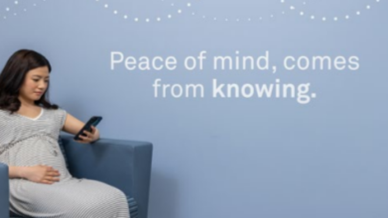 A person seated in a chair, looking at a cellphone. "Peace of Mind, comes from knowing."