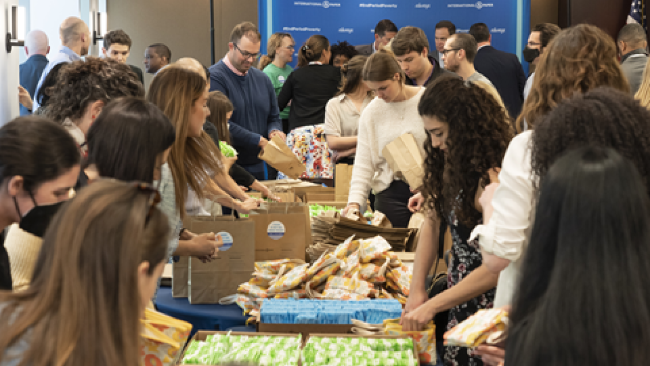 a big group of people assemble bags of period products