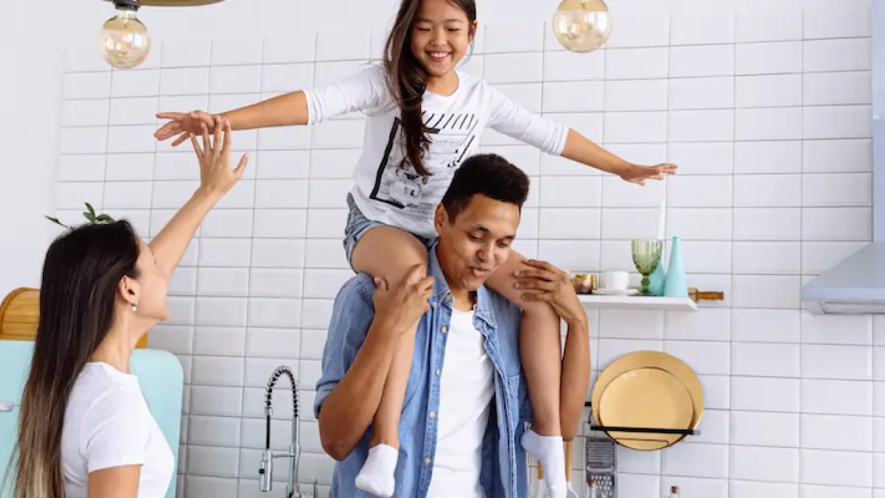 Child playing on parents shoulders