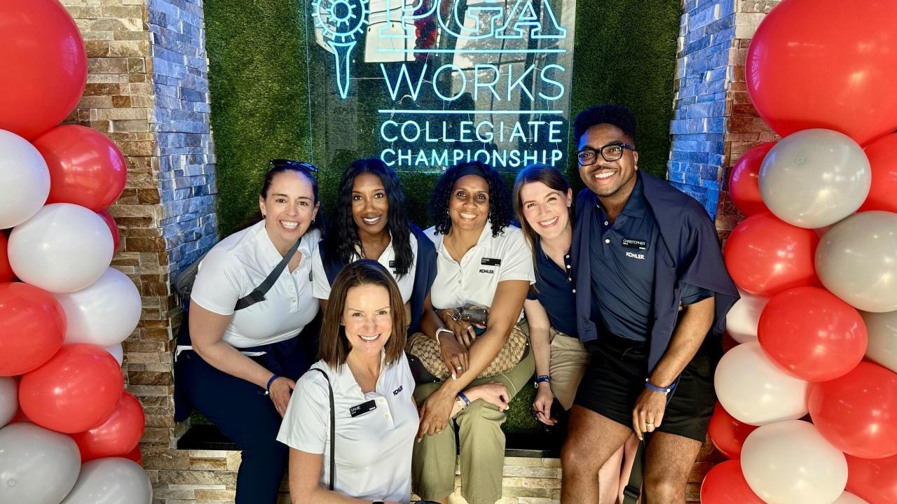A group posed with balloons in front of a PGA Works sign.