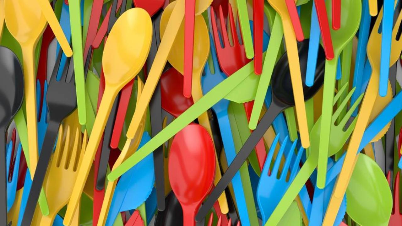 Close up of a pile of colorful plastic cutlery