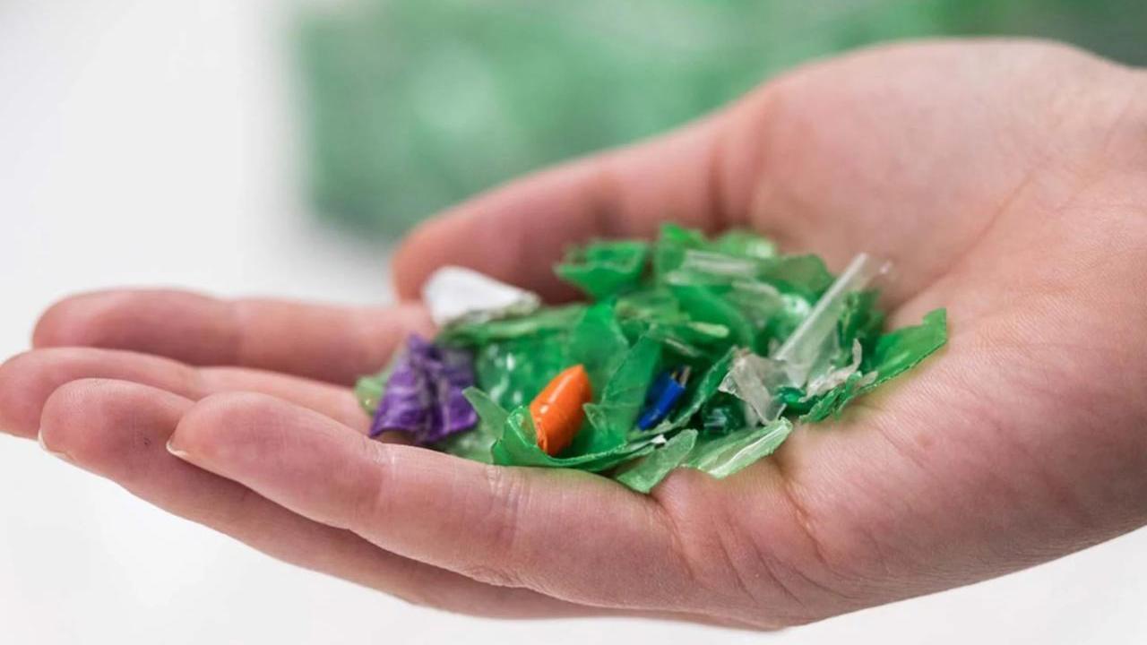 A hand holding small plastic pieces