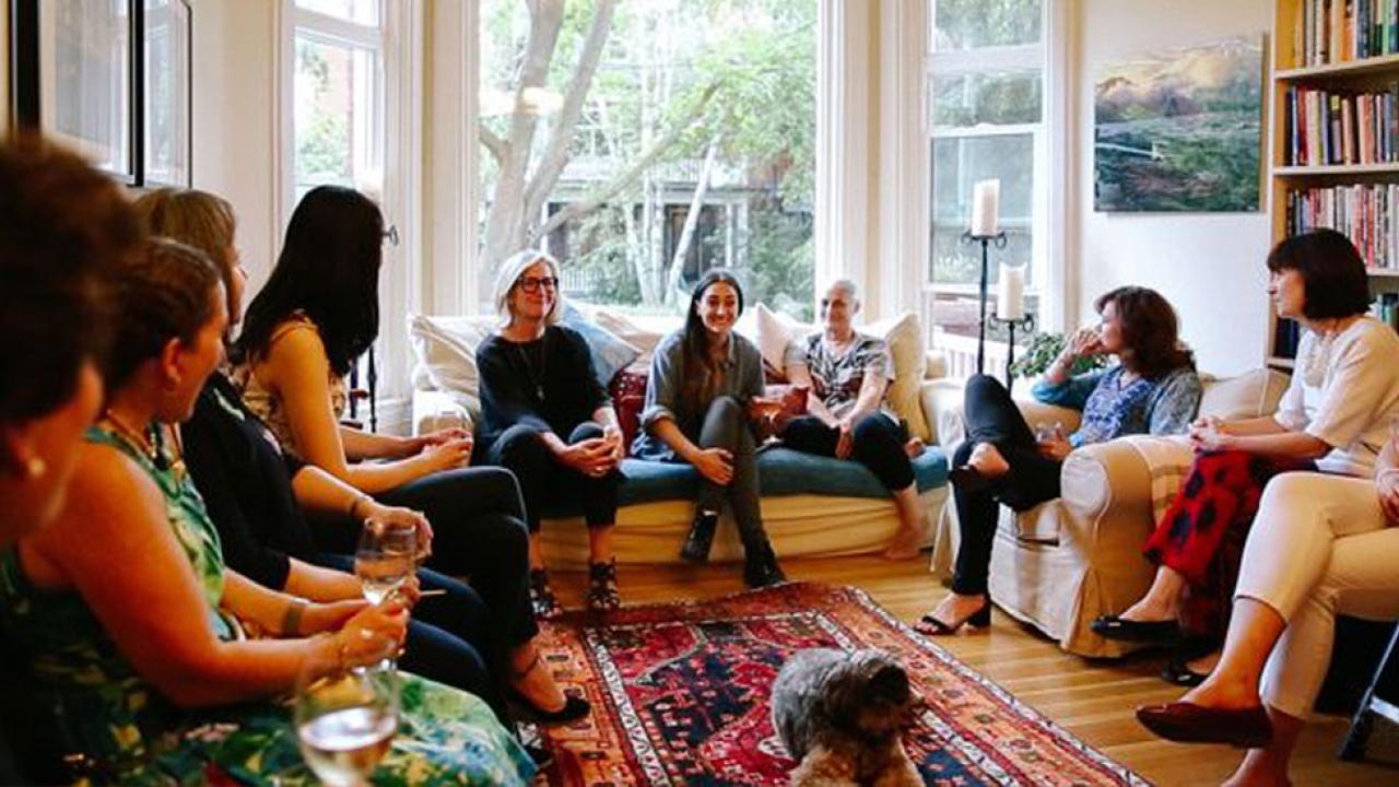 group of women holding a roundtable discussion in a living room environment