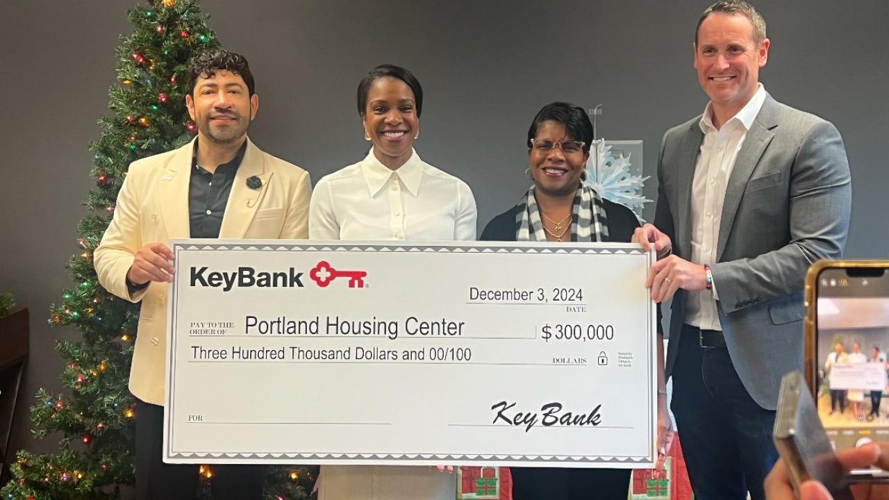 Four people holding an oversized check from KeyBank