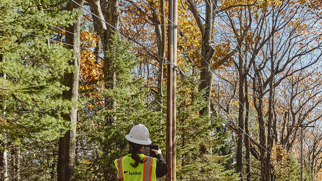 Worker looking up at powerlines
