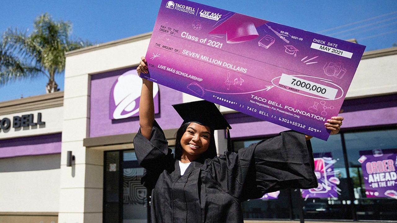 Student holding Live Mas check
