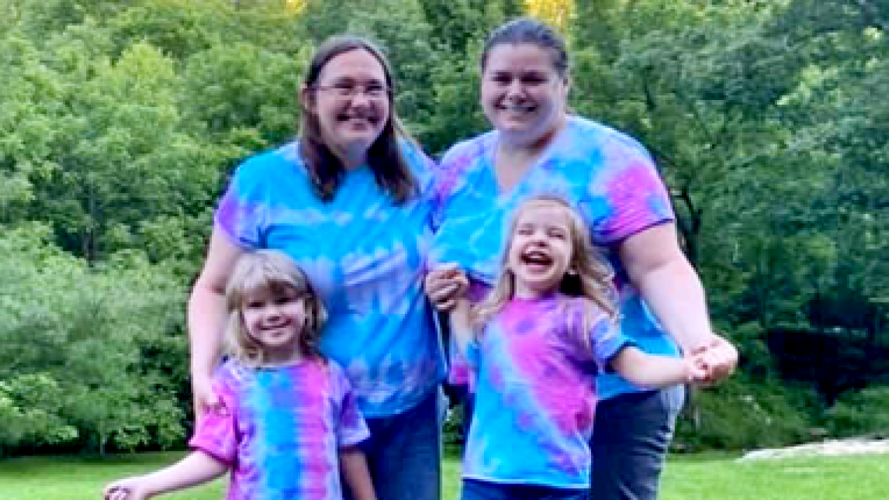 Amber with her wife and two children, all in tie-dye t-shirts