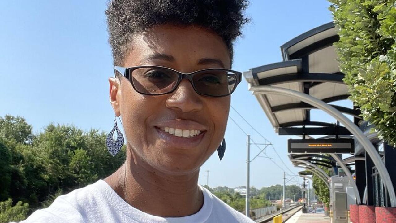 Sharene Pierce on a train platform in a rainbow "Together" shirt.