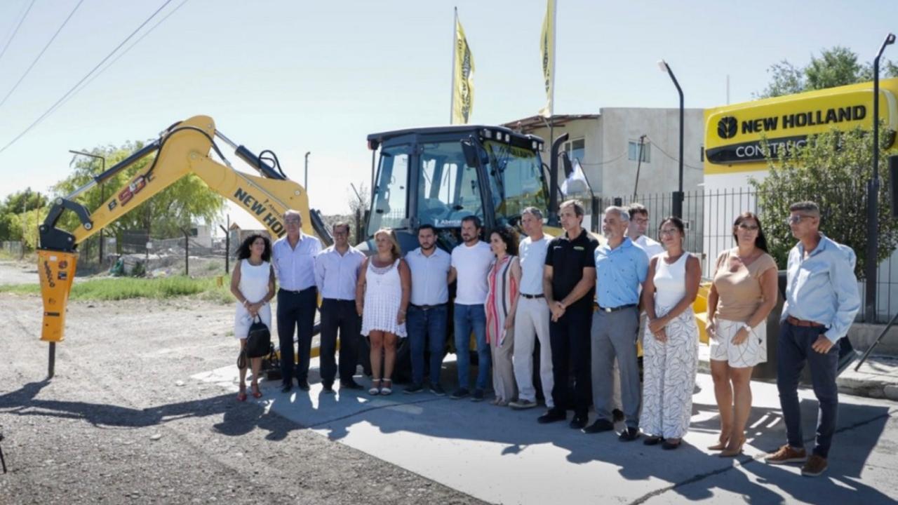 A group of people posed in front of a large construction vehicle