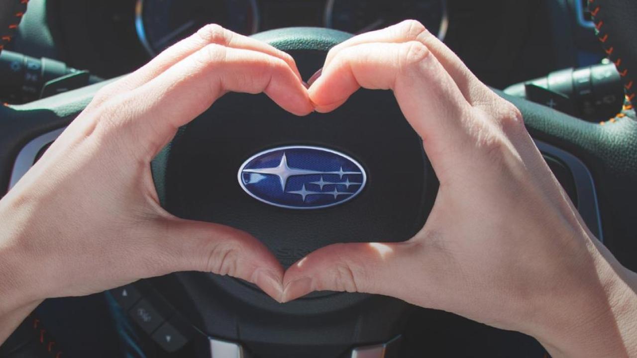 heart hands being made over Subaru steering wheel