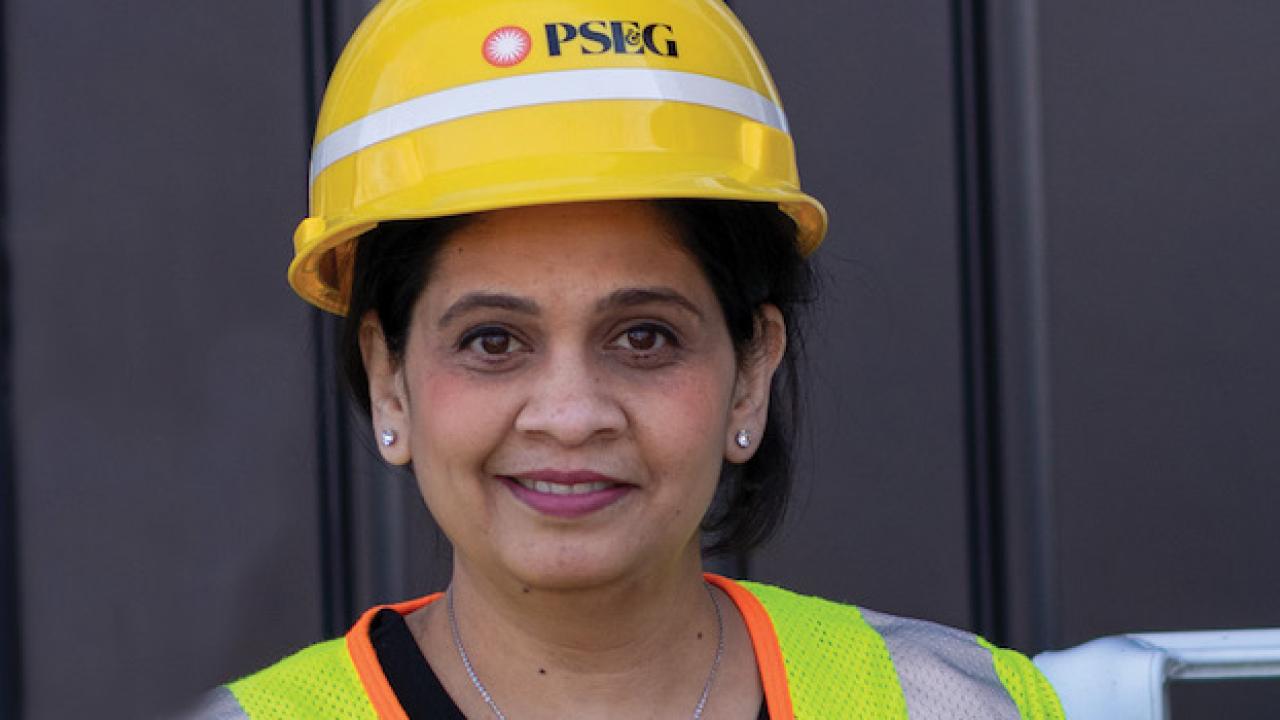 Female PSEG employee wearing a hardhat and safety vest.