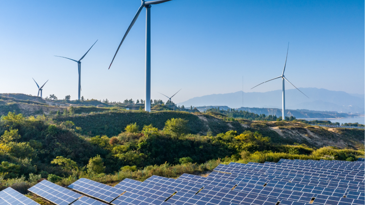 Wind turbines on a landscape next to solar panels