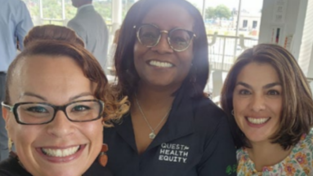 Three smiling people taking a selfie.