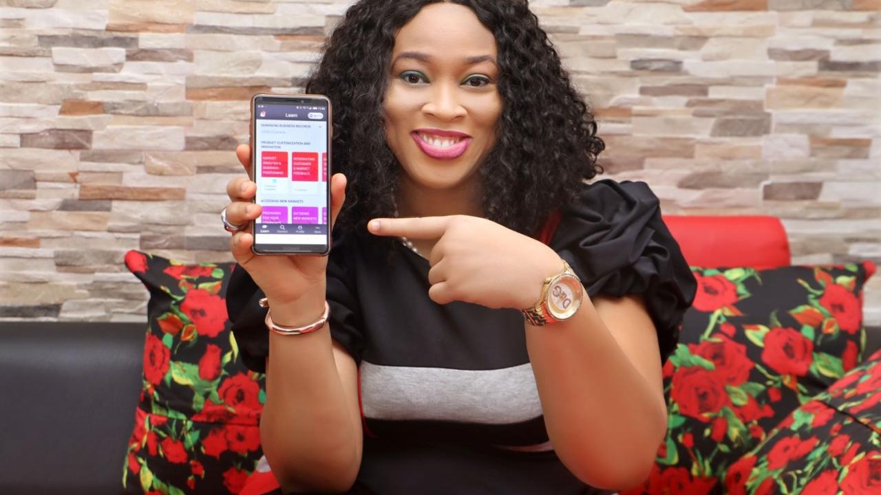 woman pointing to a phone displaying the HerVenture app