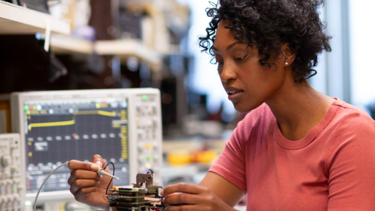 a person working on a rc vehicle, electrical equipment to their side