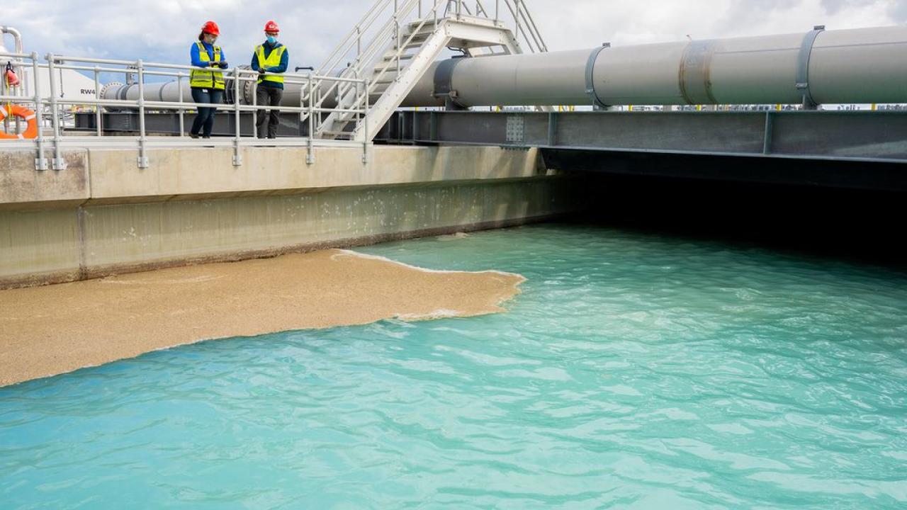 Two employees looking down on water