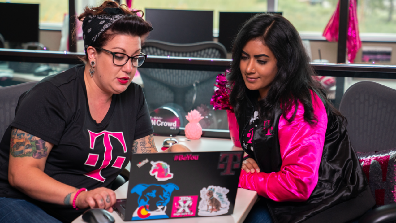 2 t-mobile employees using a laptop