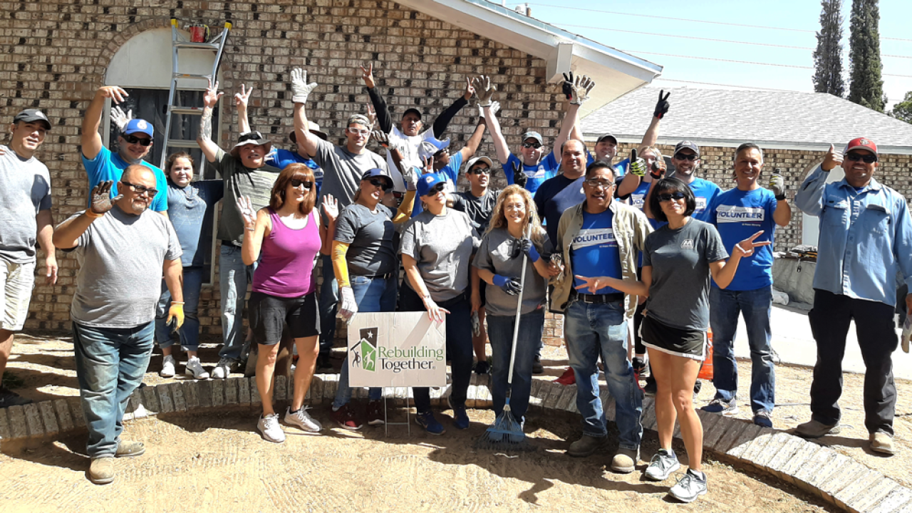 Volunteers in front of a "rebuilding together" sign