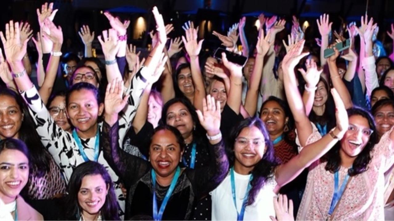 A group of people posed, arms raised.