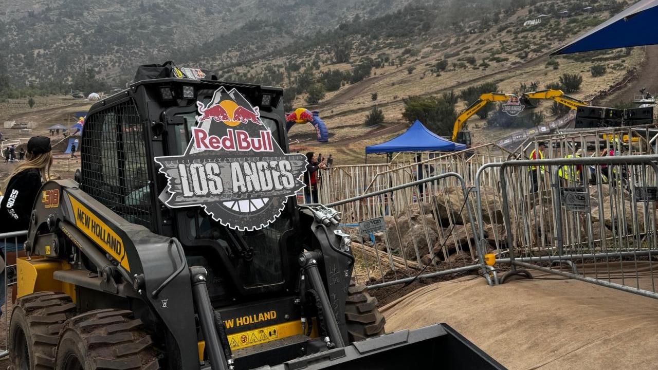 A small construction vehicle on dirt terrain. "Red Bull Los Andes" sign on the front.
