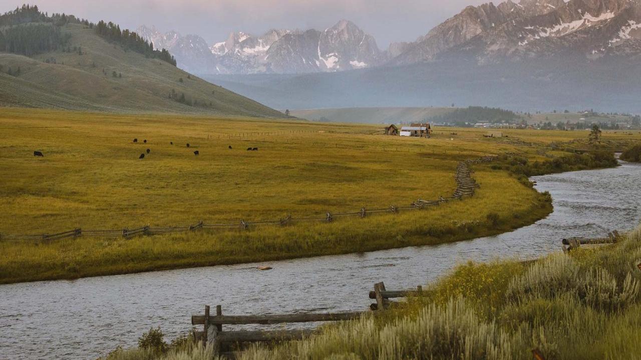 River on a farm with mountains in the background