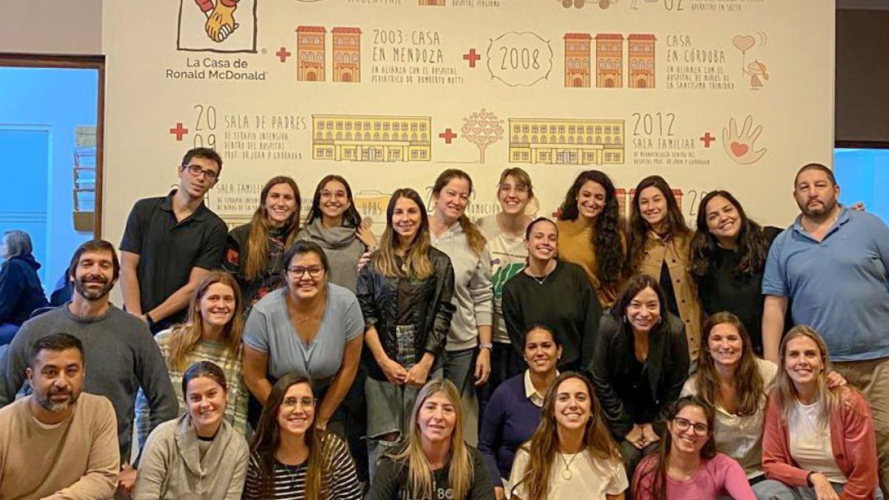 Group posed in front of a Ronald McDonald house sign.