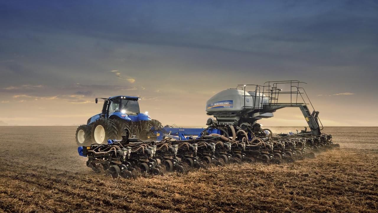 silver tractor in a golden field at dawn