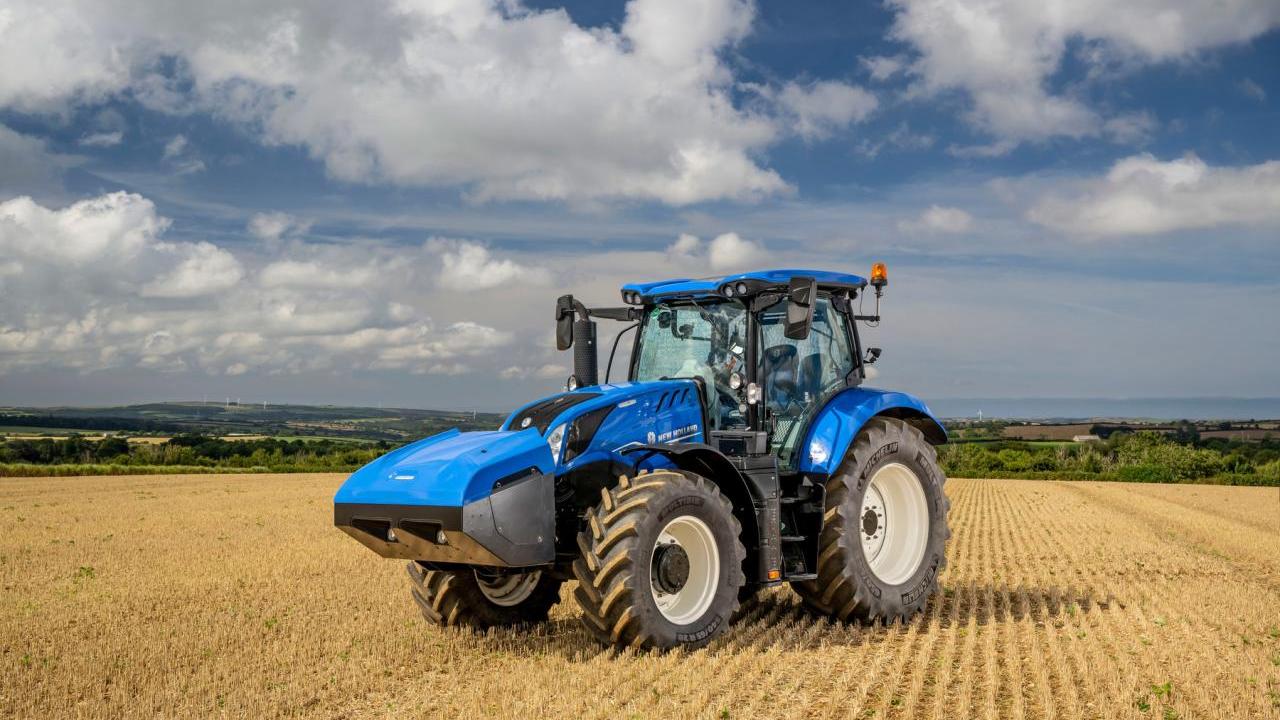 A blue tractor in a crop field.