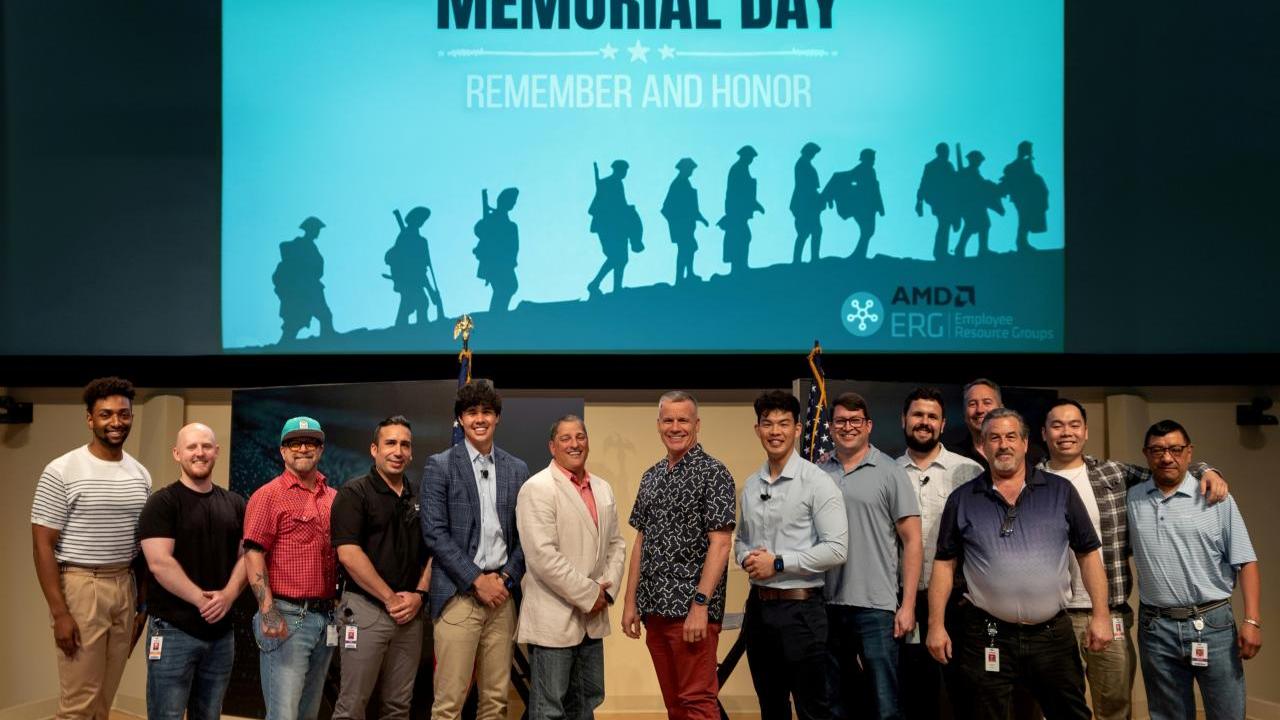Veterans posing on a stage underneath a large screen that says "Memorial Day - Remember and Honor"
