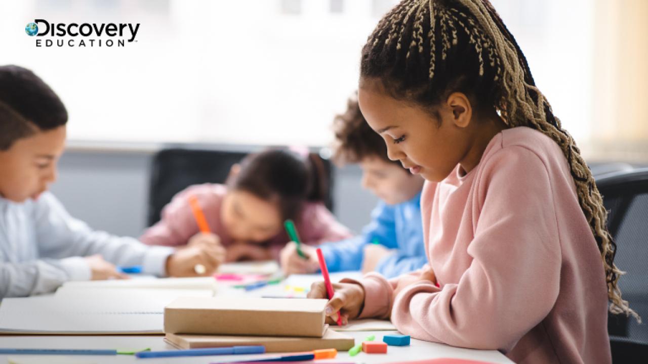 A child writing at a table with other children