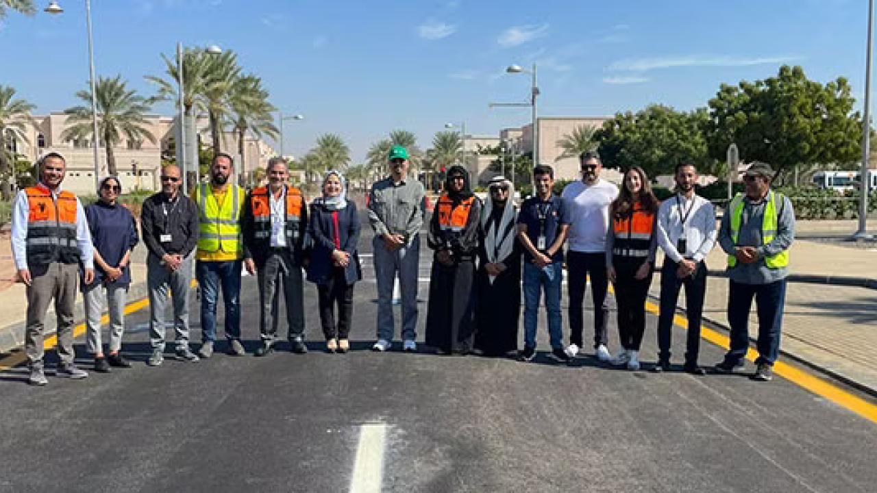 A row of people standing on a road.