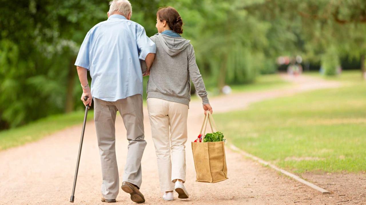 two senior citizens walking arm in arm