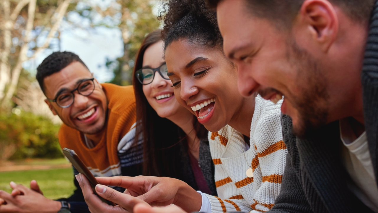 People outside smiling at their phone