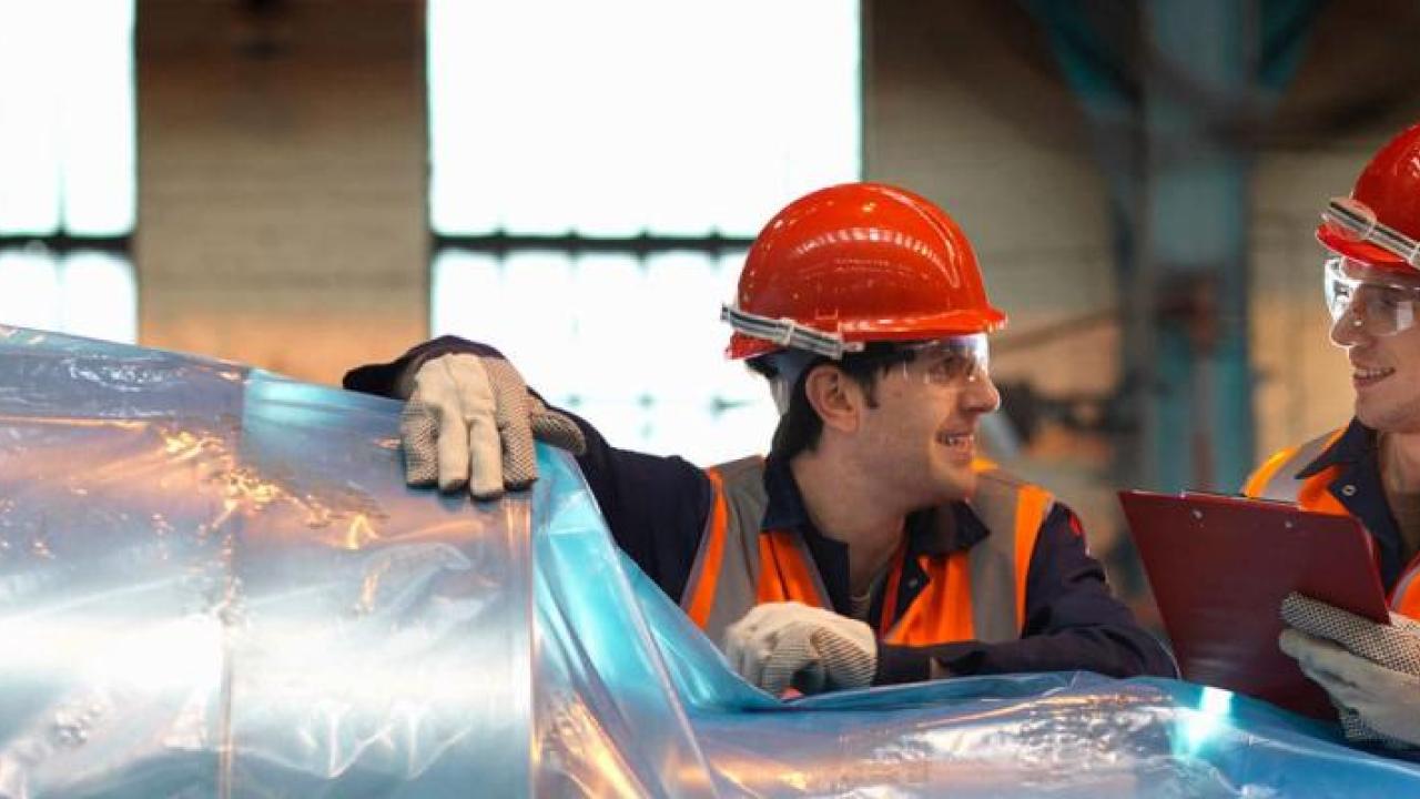 Two men wearing hard hats smiling 