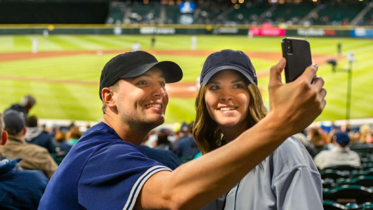 couple taking a selfie at a baseball game