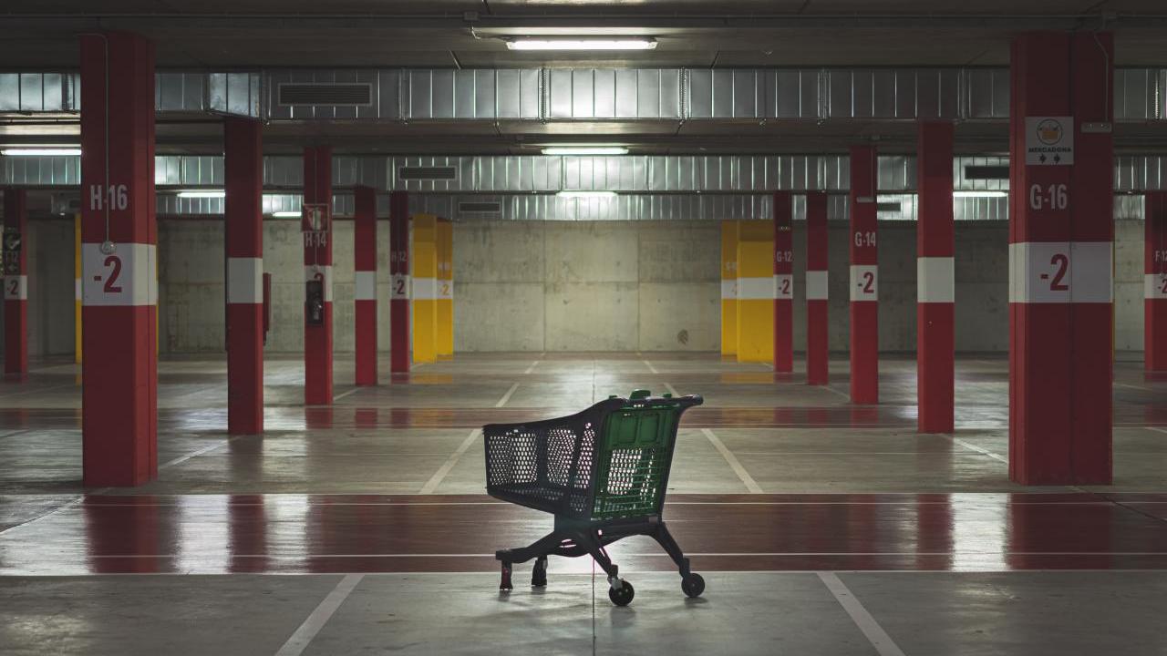 An empty parking garage and a lone grocery cart.