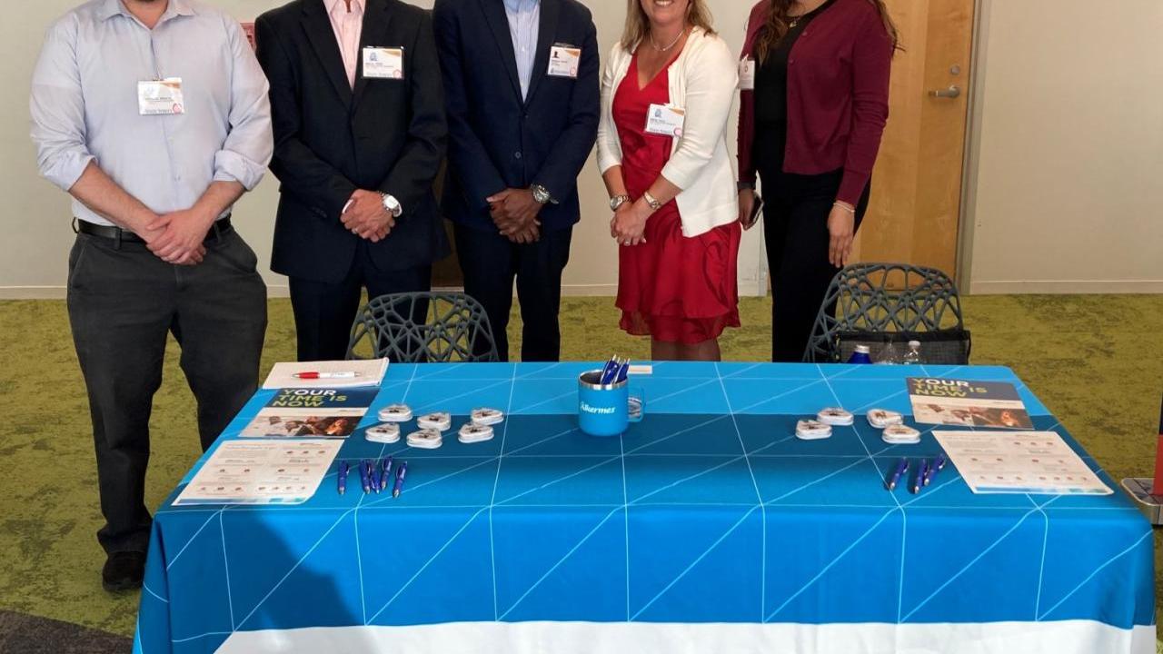 Members of Alkermes’ MOSAIC employee resource group standing behind a table 