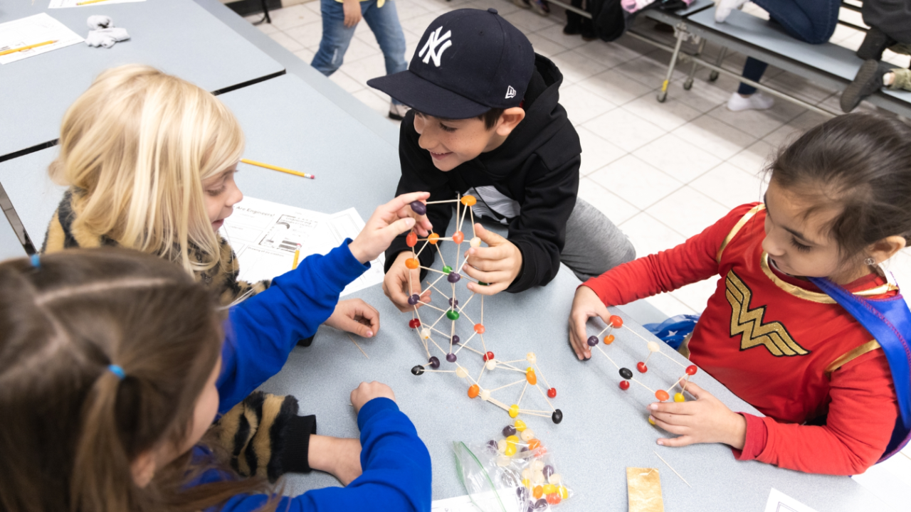 Kids building a tower with toothpicks and jelly beans