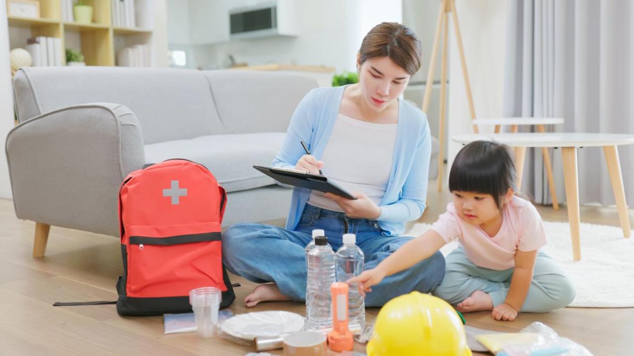 Mother and child checking emergency supplies off a list