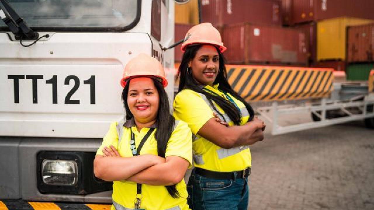 Female employees stand in a container yard at the Port of Caucedo. 