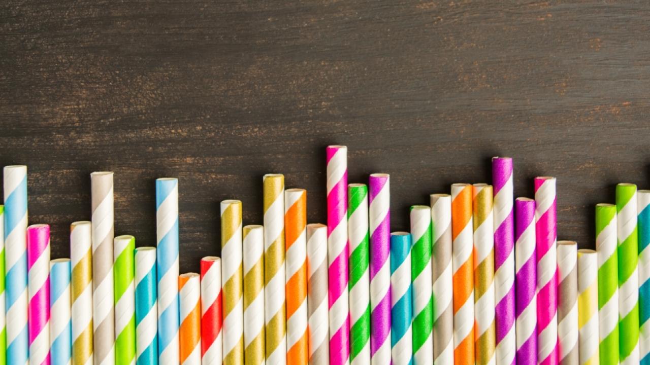 row of striped paper straws on a wood surface