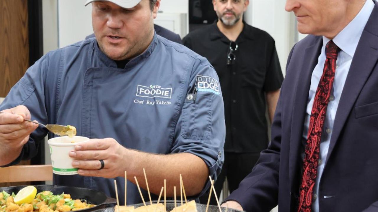 Someone dishing out food as the Senator looks on