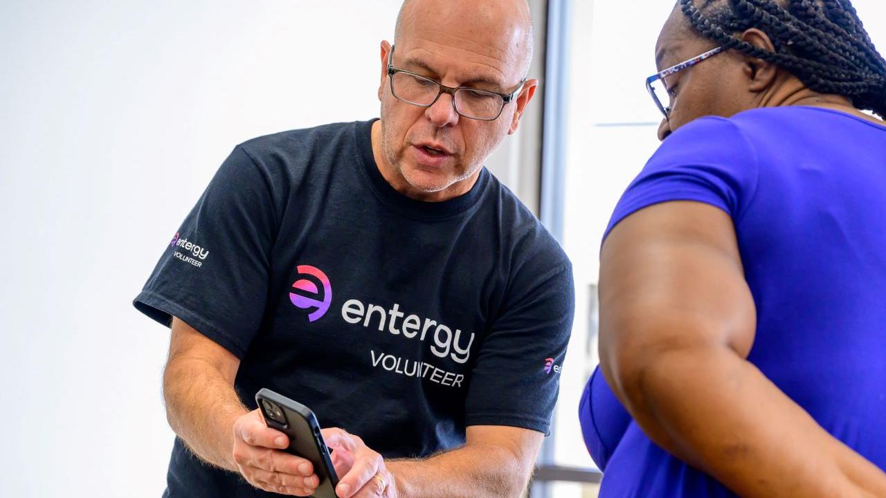 A volunteer and another person looking at a cell phone.
