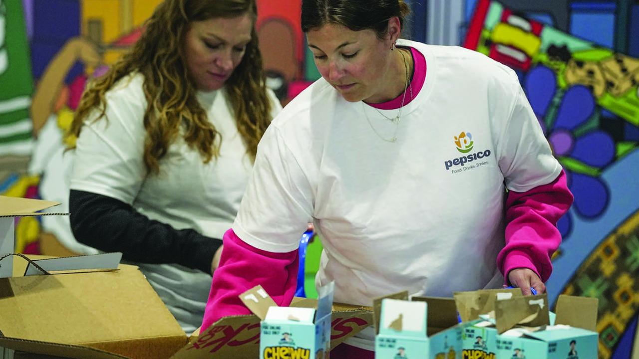 Two people in white t-shirts handling boxes