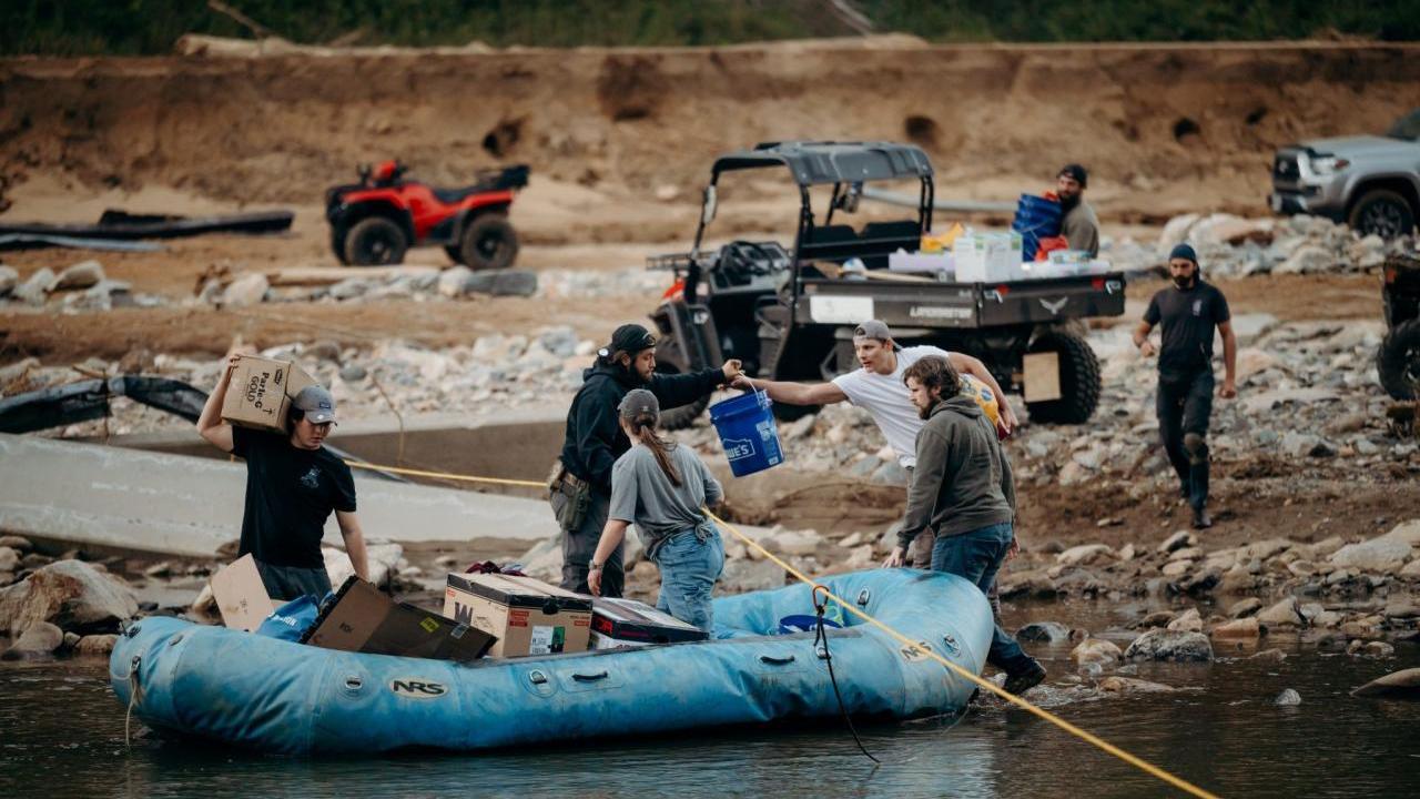 People loading supplies into an inflatable boat